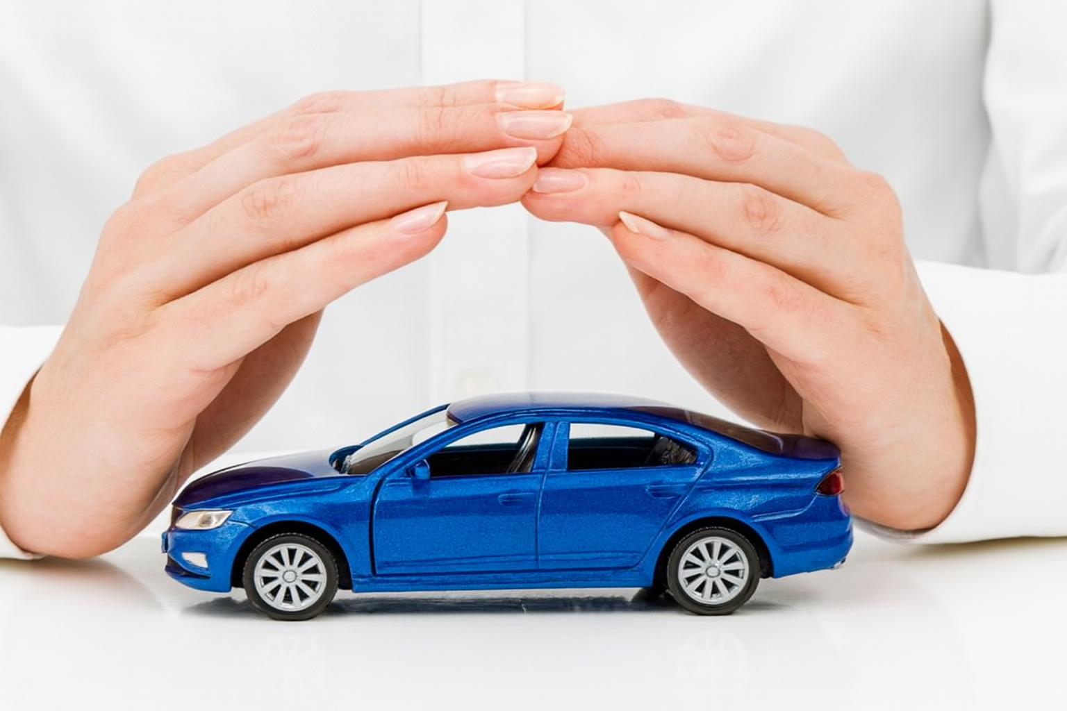 Car Extended Warranty - Protective hands covering a blue car symbolizing comprehensive warranty coverage