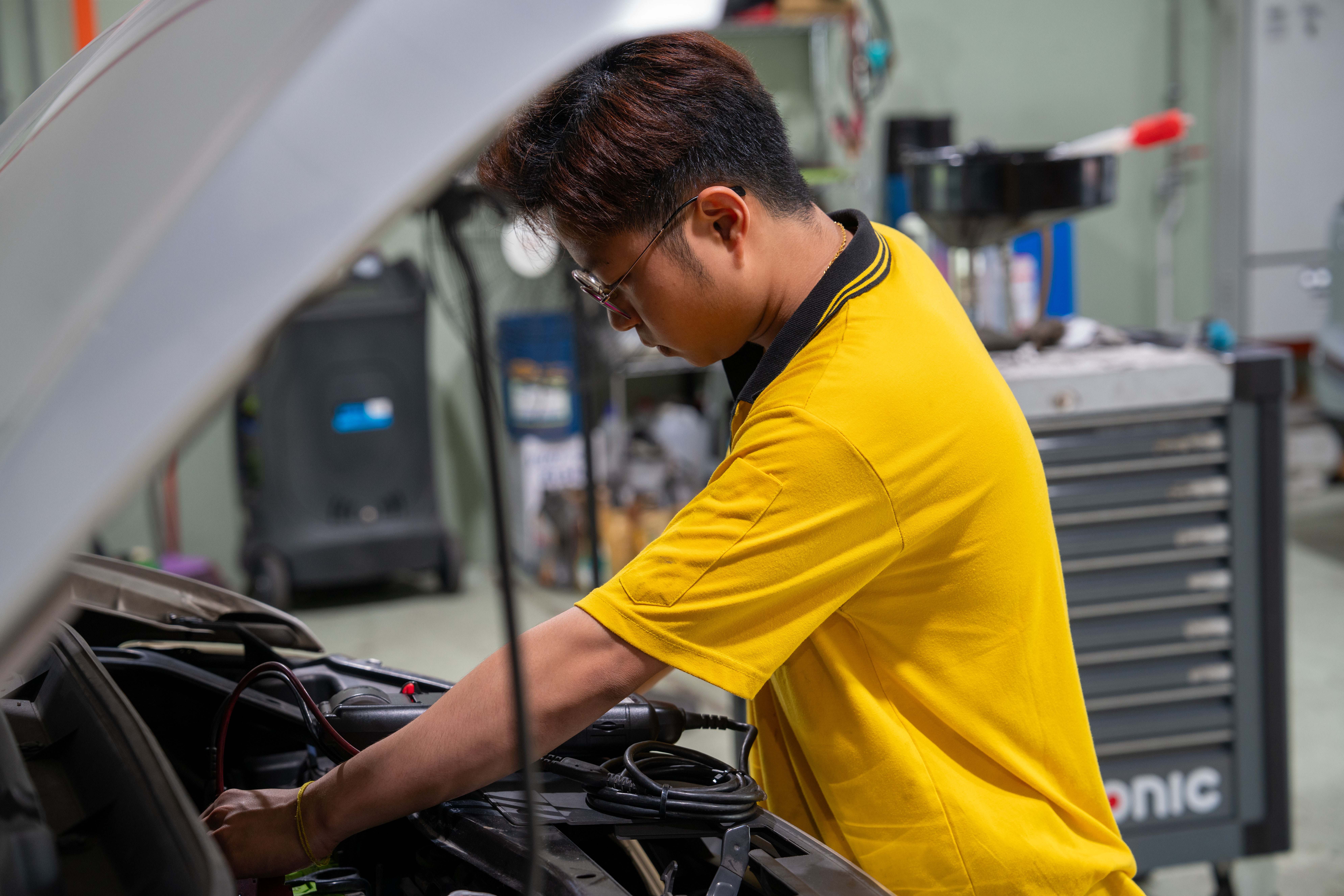 Professional mechanic working on car engine diagnostics at Autoswift Recovery workshop