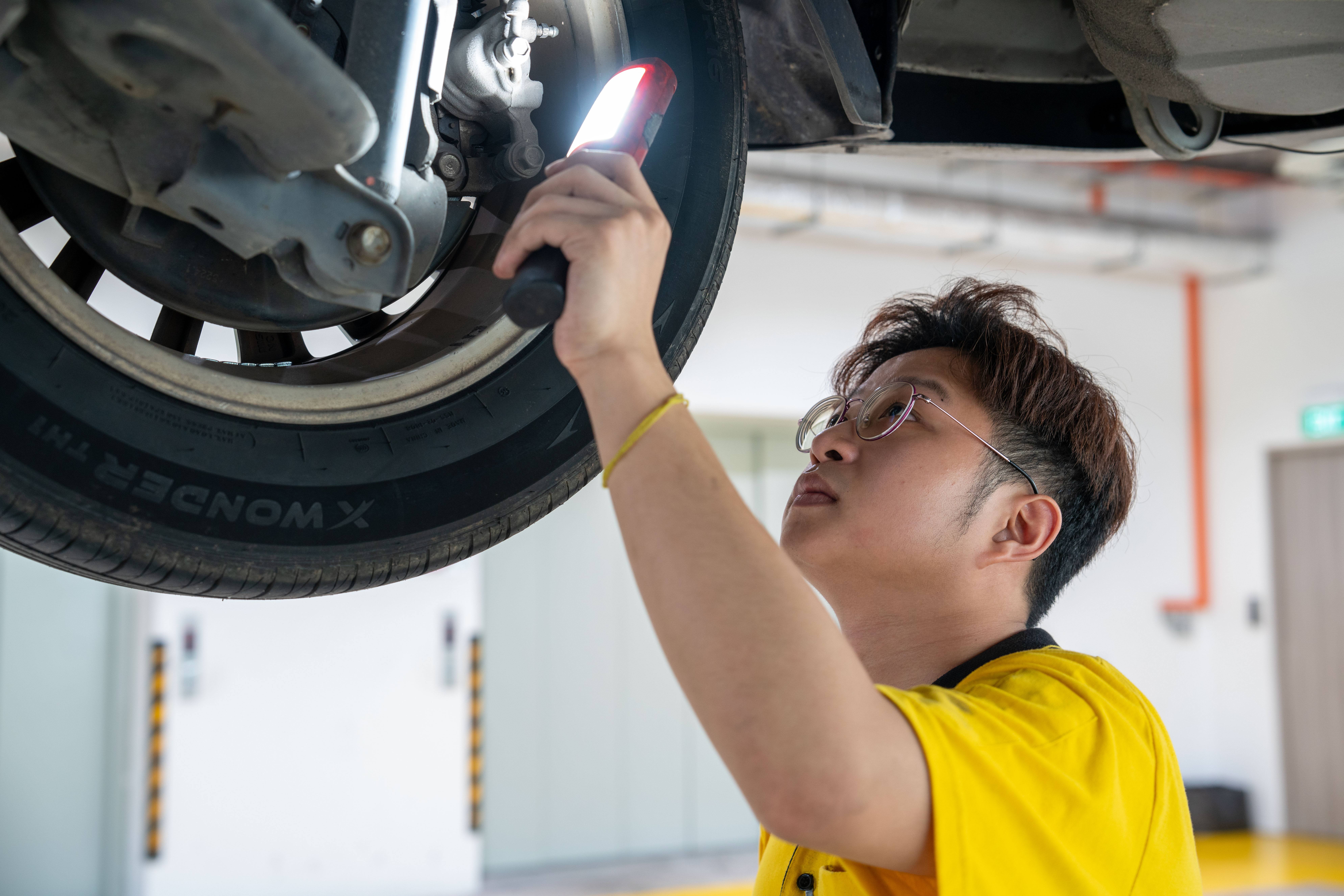 Certified technician inspecting car brake system at AA Centre workshop Singapore